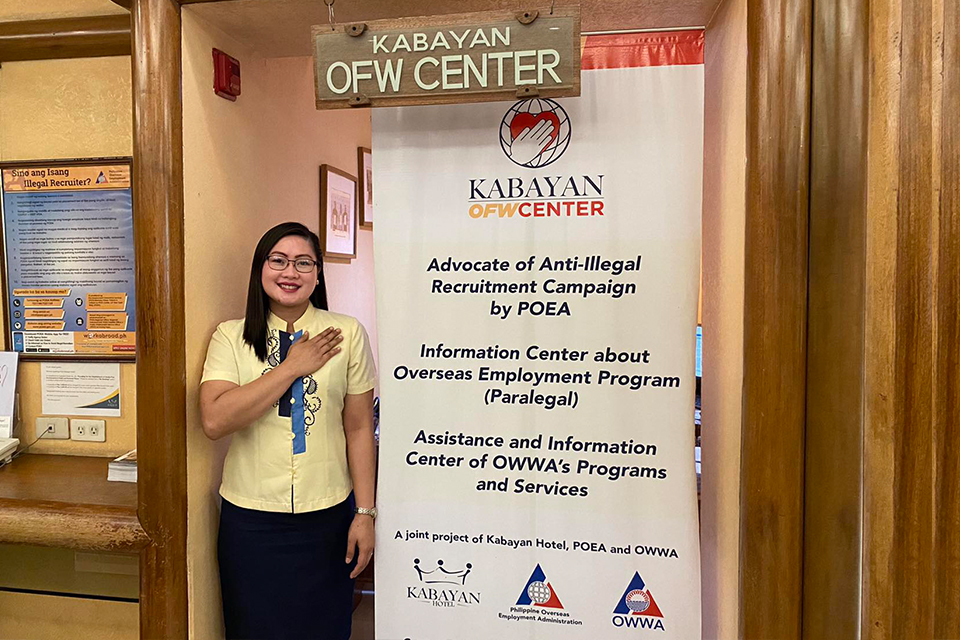 woman standing, Kabayan OFW Center banner