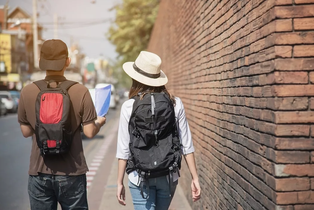 couple tourist holding city map crossing the road