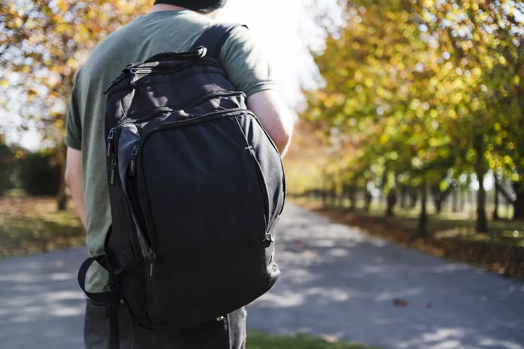 young man with backpack in the park